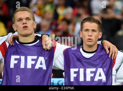 Porto Alegre, Brazil. 30th June, 2014. Germany's substitute players Christoph Kramer (L) and Matthias Ginter sing the national anthem prior to the FIFA World Cup 2014 round of 16 match between Germany and Algeria at the Estadio Beira-Rio in Porto Alegre, Brazil, 30 June 2014. Photo: Andreas Gebert/dpa/Alamy Live News Stock Photo