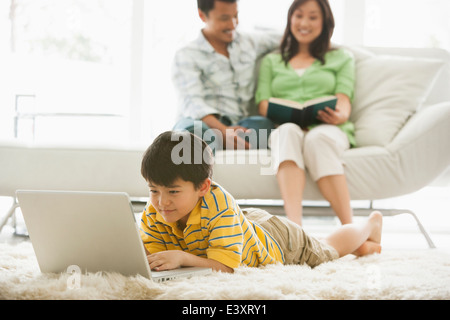 Boy using laptop in living room Stock Photo