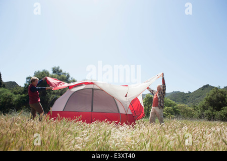 Senior Caucasian couple pitching tent in field Stock Photo