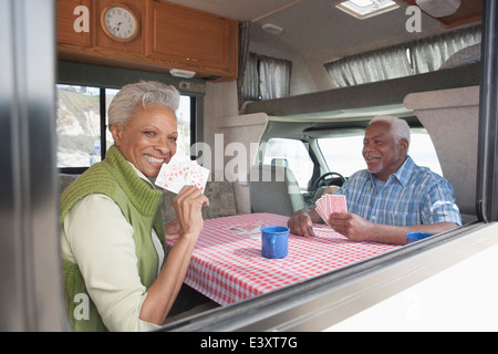 Mixed race Senior couple playing cards in RV Stock Photo