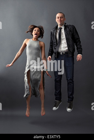 Couple jumping together in studio Stock Photo