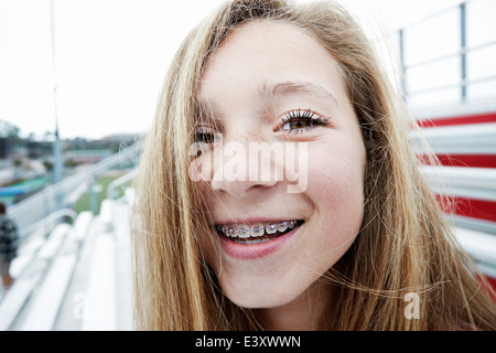 Teenage girl smiling on bleachers Stock Photo