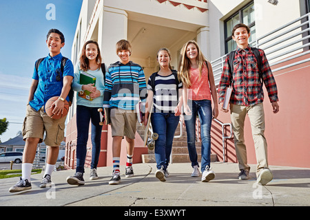 Teenagers walking out of school Stock Photo