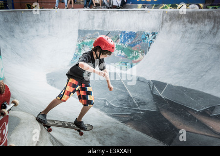 Caucasian boy riding skateboard in skate park Stock Photo