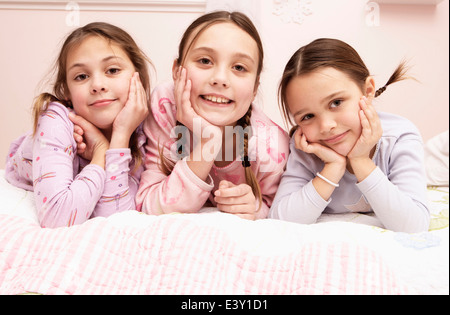 Mixed race girls laying on bed Stock Photo