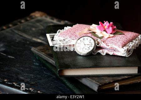 Old watch and books on vintage suitcase Stock Photo