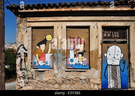Colorful graffiti happy cartoon characters on the boarded up windows and door of an abandoned house in Plaka. Stock Photo