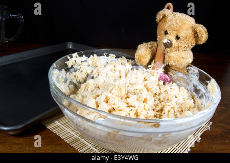 Cute teddy bear helper making puffed rice cereal cookie treats Stock Photo