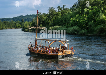 Tourists in gabare / gabarre, traditional scow, used for sightseeing tour on Dordogne River, La Roque-Gageac, Périgord, France Stock Photo