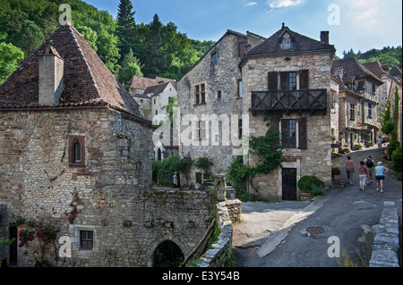 Tourists walking through the medieval village Saint-Cirq-Lapopie, Lot, Midi-Pyrénées, France Stock Photo