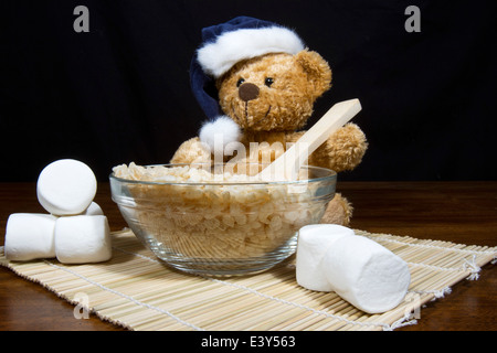 Cute Christmas bear making puffed rice cereal cookie treats Stock Photo