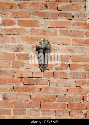 Flagstaff for two flags, very old, rusty and smeared paint on a brick wall. Stock Photo