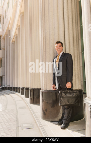 Portrait of business lawyer with briefcase outside courthouse Stock Photo