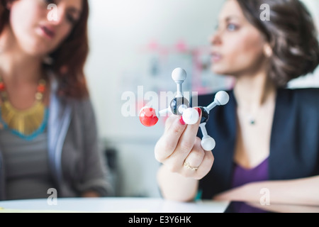 Young women discussing molecular model of Ethanol molecule