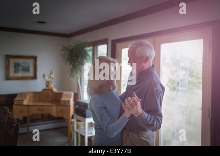 Mature couple waltzing together in dining room
