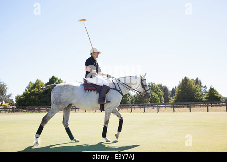 Mid adult man playing polo Stock Photo