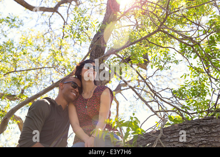 Romantic young couple gazing from tree Stock Photo