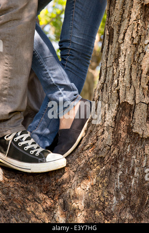 Legs and feet of young couple standing on tree Stock Photo