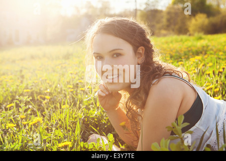 Young woman lying in field Stock Photo