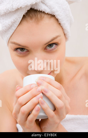 Portrait of a sensual, nude woman holding an aromatic cup of