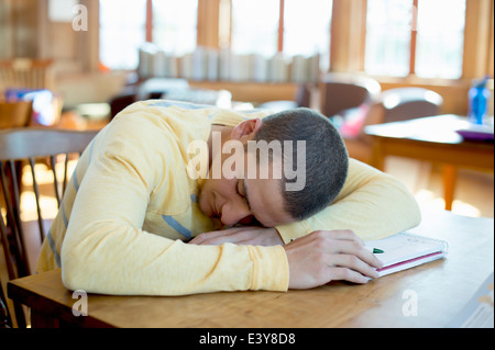 Young man asleep on book Stock Photo