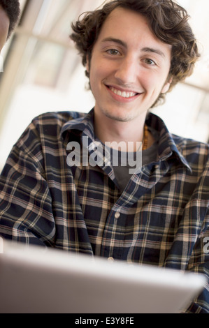 Young man wearing checked shirt, smiling Stock Photo
