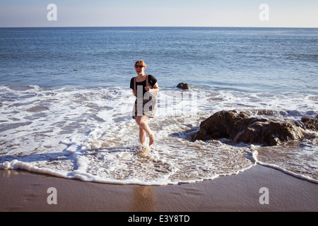Portrait of mid adult woman paddling in sea, Malibu, California, USA Stock Photo