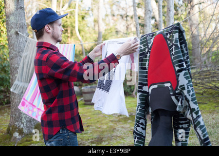 Mid adult man hanging out laundry in garden Stock Photo