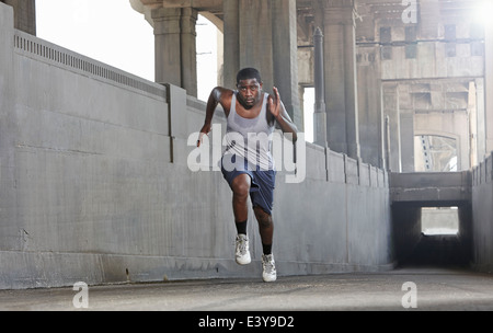 Young man speed running over city bridge Stock Photo