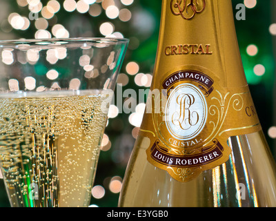 CRISTAL CHAMPAGNE Bottle and freshly poured glass of Louis Roederer Cristal luxury champagne with sparkling lights in background Stock Photo