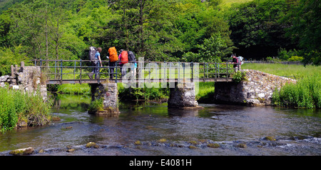 Monsal Dale, walkers on the bridge crossing the River Wye Derbyshire Peak District National Park England UK Stock Photo