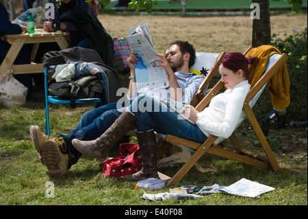 Man & woman sitting in deckchairs reading newspapers at Hay Festival 2014 ©Jeff Morgan Stock Photo