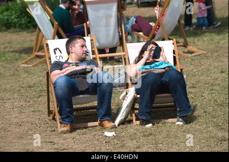 Man watching woman texting sitting in deckchairs at Hay Festival 2014 ©Jeff Morgan Stock Photo