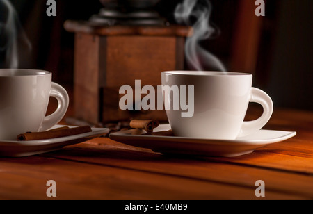 Cup of coffee and cinnamon and ancient grinder on wood table Stock Photo