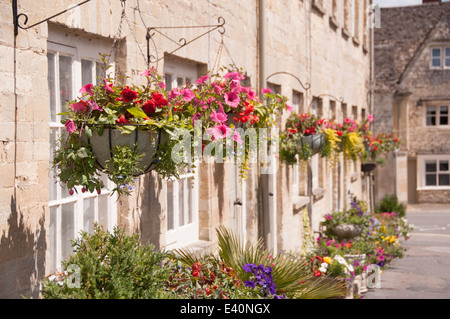 Hanging baskets outside a row of beautiful cottages terraced houses in the summertime Stock Photo