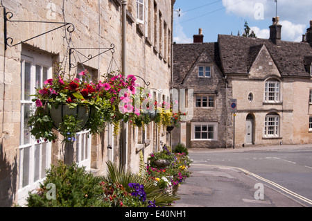 Hanging baskets outside a row of beautiful cottages terraced houses in the summertime Stock Photo