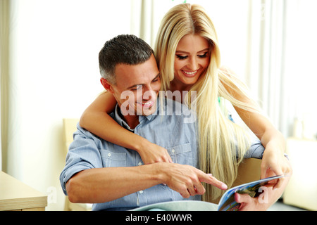 Young couple reading magazine at home Stock Photo