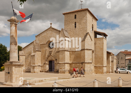 French church in Coulon with tricolor flying outside. Stock Photo