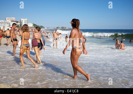 RIO DE JANEIRO, BRAZIL - JANUARY 20, 2014: Brazilian men and women enjoy a summer day on the shore of Ipanema Beach. Stock Photo