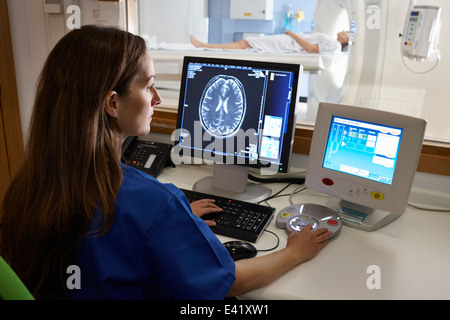Radiologist looking at brain scan image on computer screen Stock Photo