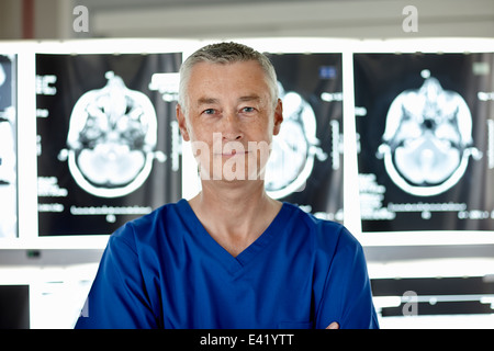 Radiologist standing in front of brain scans Stock Photo
