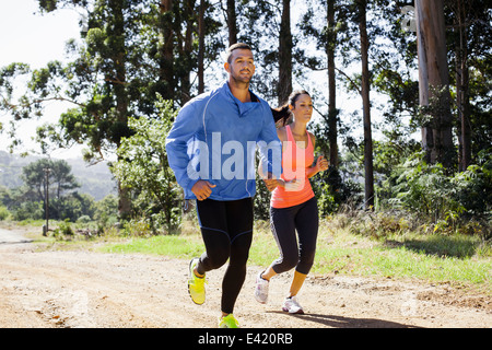 Young couple jogging in forest Stock Photo