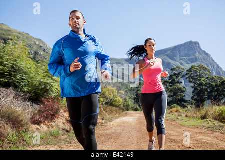 Young couple jogging in forest Stock Photo