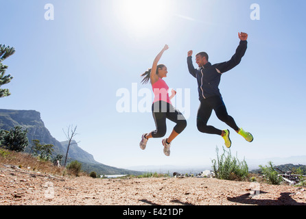 Young joggers jumping in mid air Stock Photo