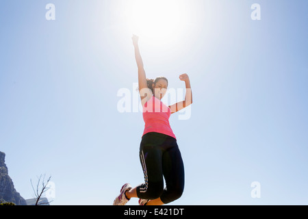 Female jogger jumping in mid air Stock Photo