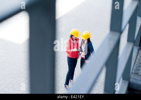 Businesswomen in safety helmet using digital tablet Stock Photo