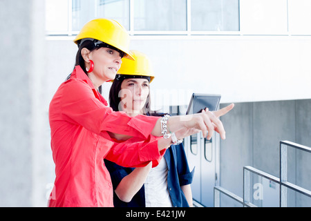 Businesswomen in safety helmet taking photograph Stock Photo