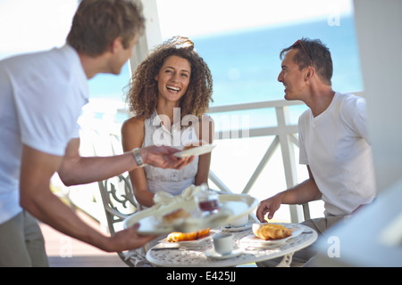 Couple having breakfast on beach house balcony Stock Photo