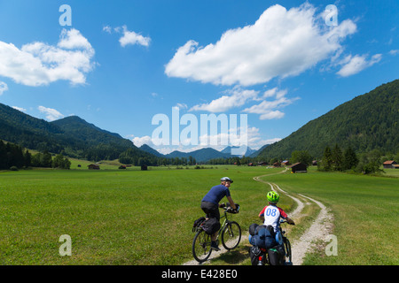 Father and son cycling through Jachenau, Bavaria, Germany Stock Photo