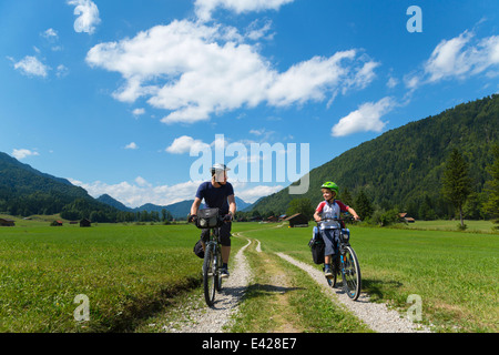 Father and son cycling through Jachenau, Bavaria, Germany Stock Photo